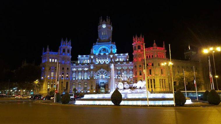 Los colores de la bandera francesa lucen en la fachada de Cibeles durante los tres días de luto oficial.